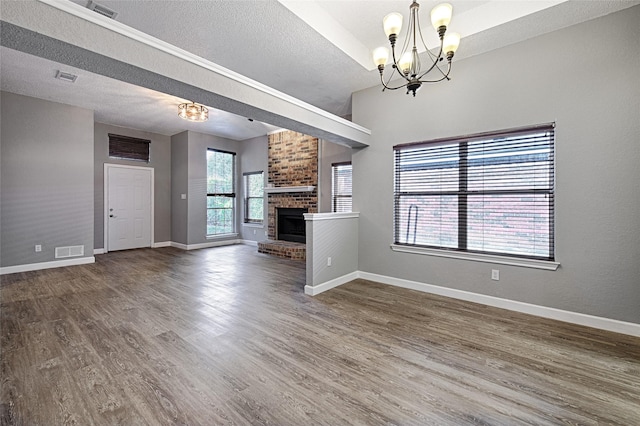 3019 Lela St, Irving, TX 75061 - unfurnished living room featuring a chandelier, a textured ceiling, wood finished floors, and a fireplace