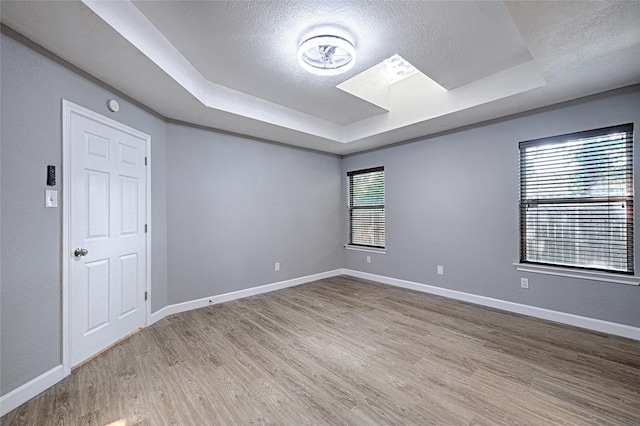 3019 Lela St, Irving, TX 75061 - unfurnished room featuring a raised ceiling, a textured ceiling, wood finished floors, and a skylight