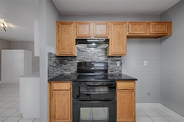 3019 Lela St, Irving, TX 75061 - kitchen featuring under cabinet range hood, range with two ovens, light tile patterned floors, decorative backsplash, and dark stone counters