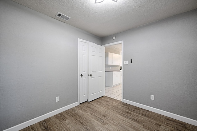 3019 Lela St, Irving, TX 75061 - unfurnished bedroom with wood finished floors and a textured ceiling