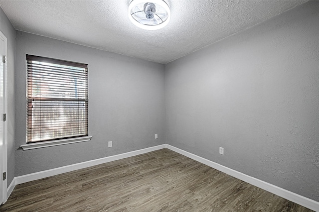 3019 Lela St, Irving, TX 75061 - empty room featuring a textured ceiling and dark wood-type flooring