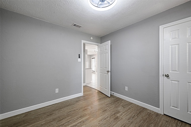 3019 Lela St, Irving, TX 75061 - unfurnished bedroom featuring wood finished floors and a textured ceiling