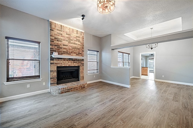 3019 Lela St, Irving, TX 75061 - unfurnished living room featuring a textured ceiling, wood finished floors, and a brick fireplace