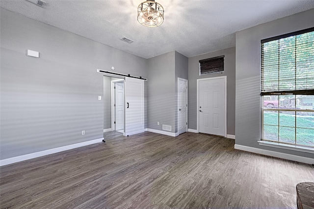 3019 Lela St, Irving, TX 75061 - entryway with a barn door, dark wood-type flooring, a textured ceiling, and healthy amount of natural light