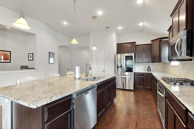 691 Hobie Point Dr, Lewisville, TX 75056 - kitchen with stainless steel appliances, a sink, dark wood-type flooring, arched walkways, and a center island with sink
