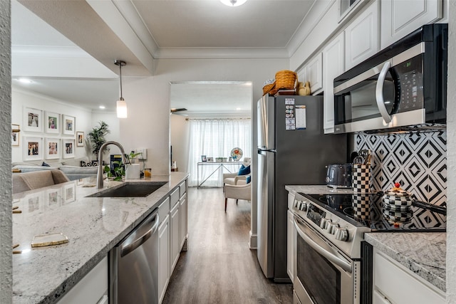 5927 E University Blvd Unit 217, Dallas, TX 75206 - kitchen featuring stainless steel appliances, a sink, dark wood finished floors, white cabinetry, and crown molding