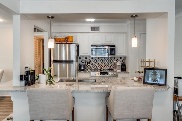 5927 E University Blvd Unit 217, Dallas, TX 75206 - kitchen with appliances with stainless steel finishes, backsplash, a peninsula, white cabinetry, and light stone counters