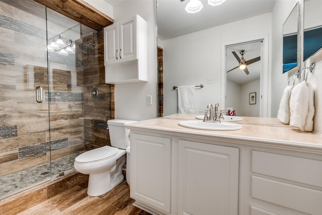 5927 E University Blvd Unit 217, Dallas, TX 75206 - bathroom with wood finished floors, toilet, a stall shower, vanity, and ceiling fan
