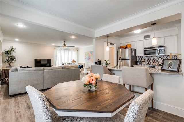 5927 E University Blvd Unit 217, Dallas, TX 75206 - dining space featuring crown molding, wood finished floors, recessed lighting, a ceiling fan, and baseboards