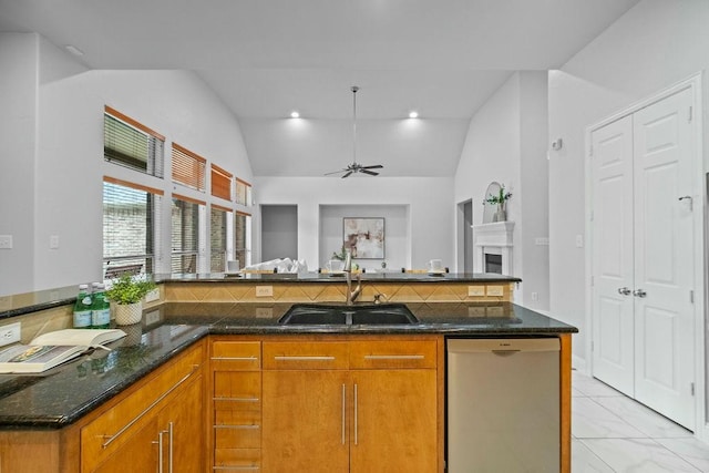2425 Sir Lovel Ln, Lewisville, TX 75056 - kitchen with dishwasher, a sink, brown cabinets, lofted ceiling, and dark stone countertops