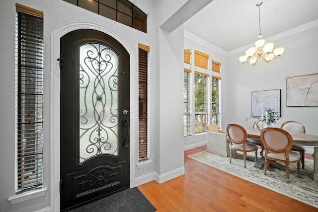 2425 Sir Lovel Ln, Lewisville, TX 75056 - entryway with a chandelier, crown molding, wood finished floors, baseboards, and arched walkways