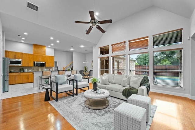 2425 Sir Lovel Ln, Lewisville, TX 75056 - living room featuring high vaulted ceiling, a ceiling fan, light wood-style flooring, recessed lighting, and stairs