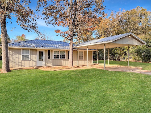 6021 Fm 3054, Malakoff, TX 75148 - back of house featuring board and batten siding, a carport, a yard, and metal roof