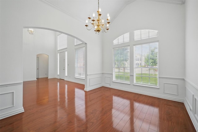 518 Hawthorne Dr, Murphy, TX 75094 - spare room with arched walkways, a chandelier, wainscoting, wood finished floors, and ornamental molding