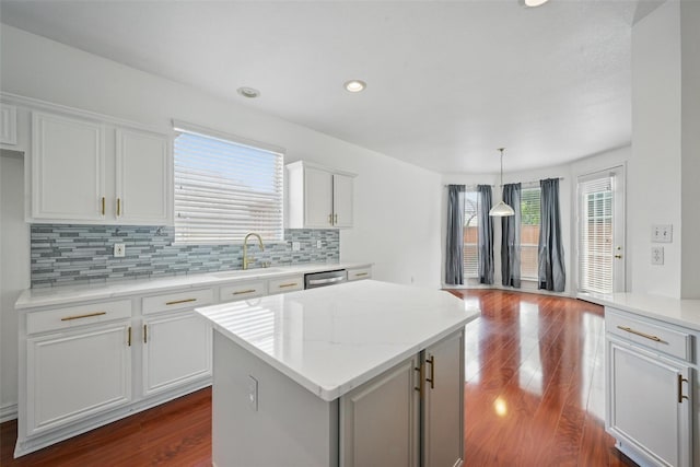 518 Hawthorne Dr, Murphy, TX 75094 - kitchen featuring a sink, a center island, dark wood finished floors, decorative backsplash, and dishwasher