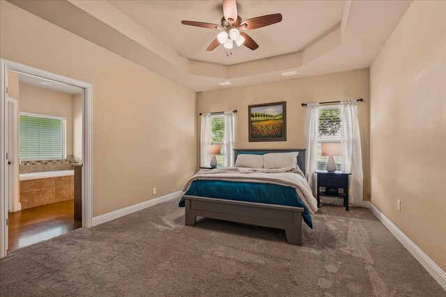 5861 Hayes Rd, Midlothian, TX 76065 - carpeted bedroom featuring a tray ceiling, baseboards, connected bathroom, and ceiling fan