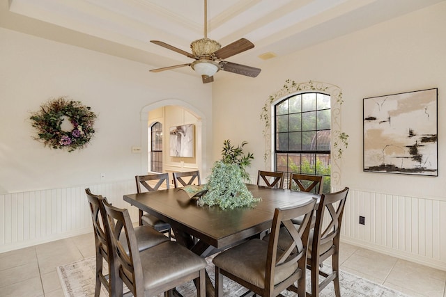 201 Split Rock Ter, Ovilla, TX 75154 - dining room with light tile patterned floors, ceiling fan, a decorative wall, arched walkways, and wainscoting