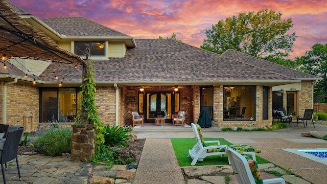 201 Split Rock Ter, Ovilla, TX 75154 - back of house at dusk with a patio, brick siding, and an outdoor living space