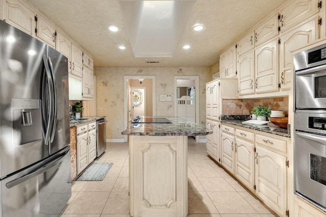 201 Split Rock Ter, Ovilla, TX 75154 - kitchen featuring appliances with stainless steel finishes, a kitchen island, dark stone counters, recessed lighting, and decorative backsplash