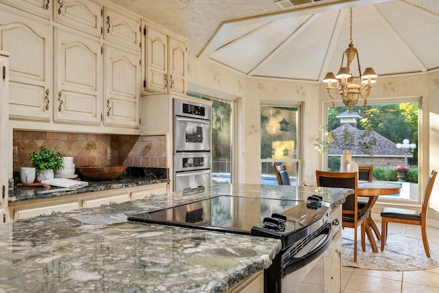 201 Split Rock Ter, Ovilla, TX 75154 - kitchen featuring cream cabinetry, black range with electric cooktop, tasteful backsplash, a chandelier, and double oven
