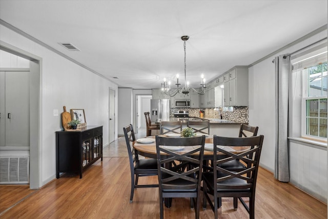 809 S Prairieville St, Athens, TX 75751 - dining space with a chandelier, light wood-style floors, and ornamental molding
