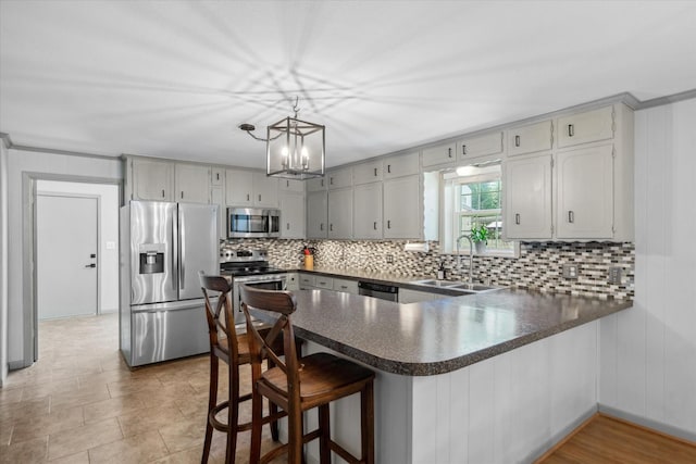 809 S Prairieville St, Athens, TX 75751 - kitchen with stainless steel appliances, a sink, dark countertops, a peninsula, and backsplash