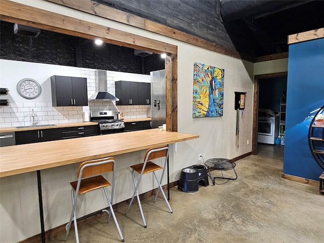 13597 County Road 35, Tyler, TX 75706 - kitchen with butcher block counters, gas stove, wall chimney range hood, dark cabinetry, and a sink