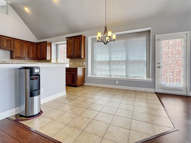 5973 Country View Ln, Frisco, TX 75036 - kitchen featuring a chandelier, tasteful backsplash, hanging light fixtures, lofted ceiling, and baseboards
