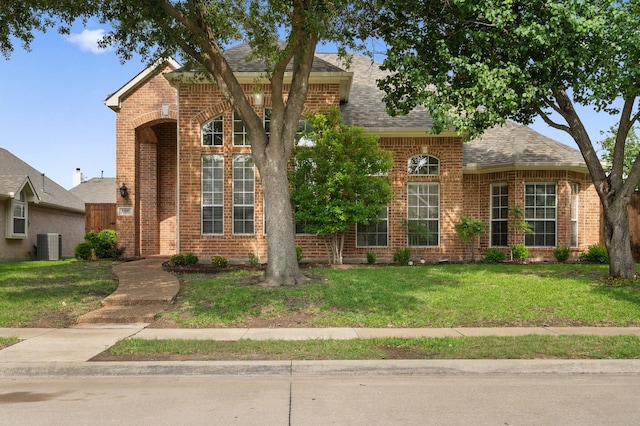 8400 Halliford Ct, Plano, TX 75024 - traditional-style house with brick siding, a front yard, a shingled roof, and central AC unit