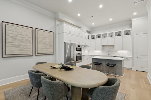 1460 N Ave, Plano, TX 75074 - kitchen with high end fridge, ornamental molding, white cabinets, light countertops, and a center island