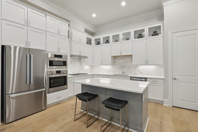 1460 N Ave, Plano, TX 75074 - kitchen featuring stainless steel appliances, a sink, white cabinets, a breakfast bar, and light countertops
