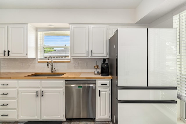 529 Doubletree Dr, Highland Village, TX 75077 - kitchen with stainless steel dishwasher, freestanding refrigerator, a sink, white cabinets, and decorative backsplash