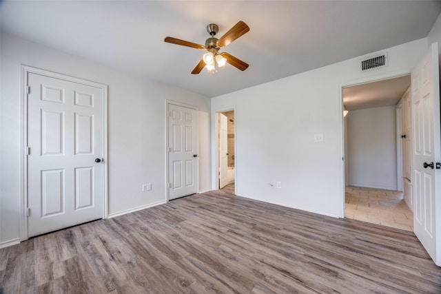 505 W Thomas St, Leonard, TX 75452 - unfurnished bedroom featuring wood finished floors, baseboards, ensuite bath, and a ceiling fan