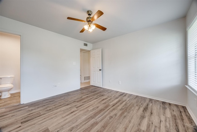505 W Thomas St, Leonard, TX 75452 - unfurnished bedroom featuring wood finished floors, ensuite bath, baseboards, and a ceiling fan