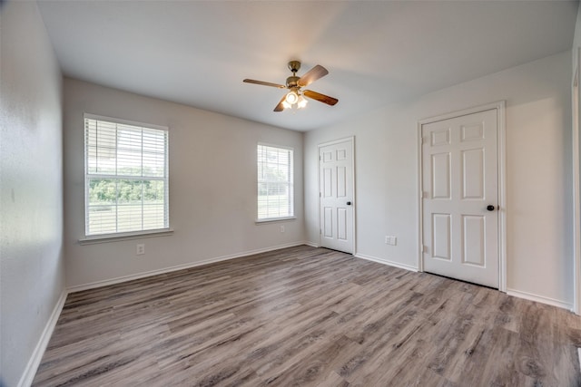 505 W Thomas St, Leonard, TX 75452 - unfurnished bedroom with wood finished floors, baseboards, a closet, and a ceiling fan