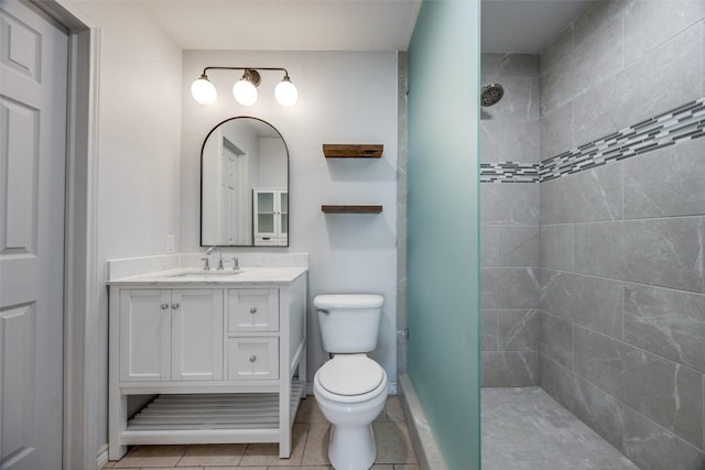 505 W Thomas St, Leonard, TX 75452 - bathroom with a tile shower, vanity, toilet, tile patterned floors, and baseboards