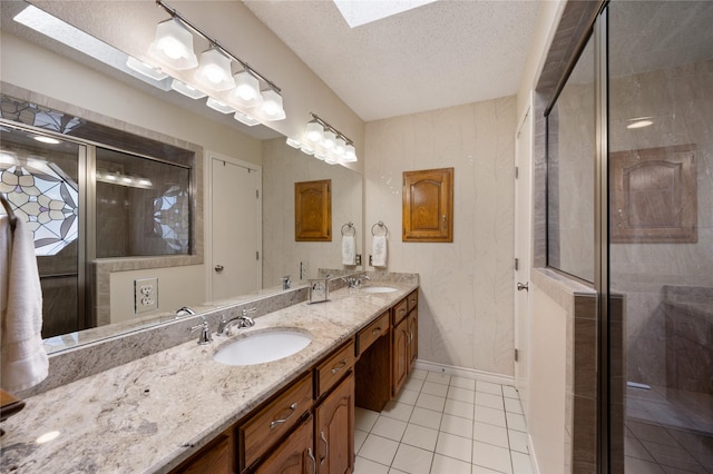 2818 Summit Ridge St, Grapevine, TX 76051 - bathroom featuring double vanity, baseboards, a skylight, tile patterned floors, and a stall shower