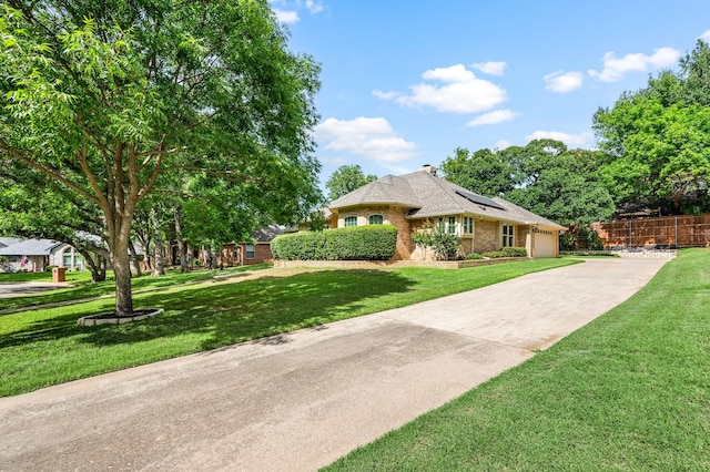 2818 Summit Ridge St, Grapevine, TX 76051 - view of front of house featuring roof mounted solar panels, concrete driveway, a garage, and brick siding