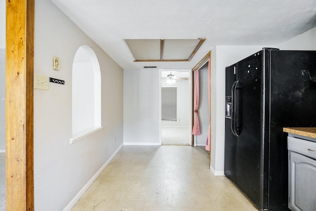 745 Oakland St, Grand Prairie, TX 75052 - kitchen with black refrigerator with ice dispenser, concrete flooring, baseboards, and arched walkways