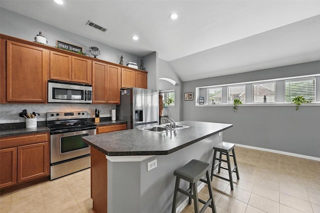 1414 Fox Glen Trl, Mansfield, TX 76063 - kitchen with appliances with stainless steel finishes, dark countertops, a sink, lofted ceiling, and brown cabinetry