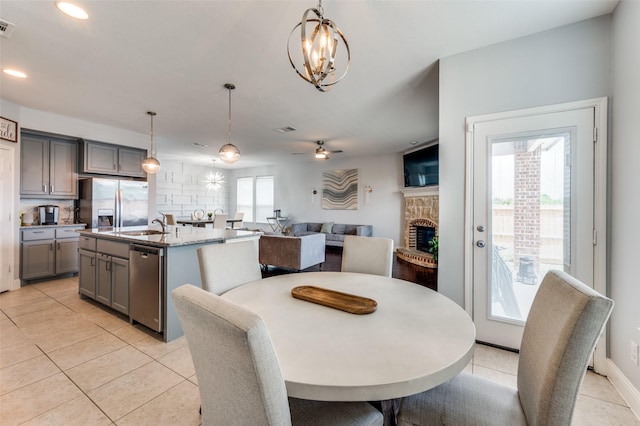 1317 Roadrunner Dr, Little Elm, TX 75068 - dining area with a fireplace, recessed lighting, a chandelier, ceiling fan, and light tile patterned floors