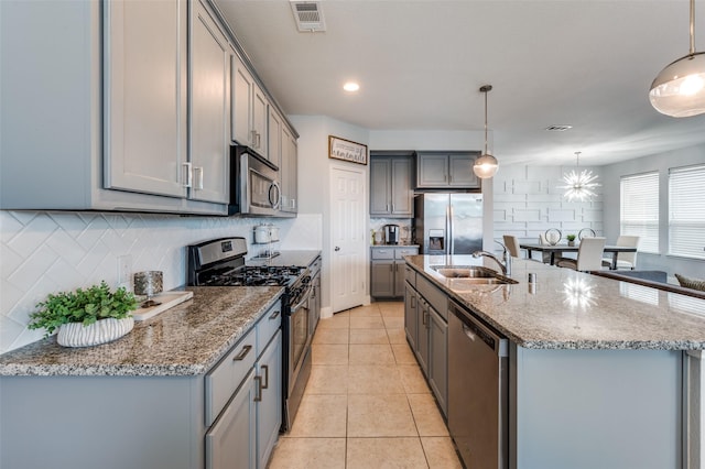 1317 Roadrunner Dr, Little Elm, TX 75068 - kitchen with appliances with stainless steel finishes, gray cabinetry, a sink, and backsplash