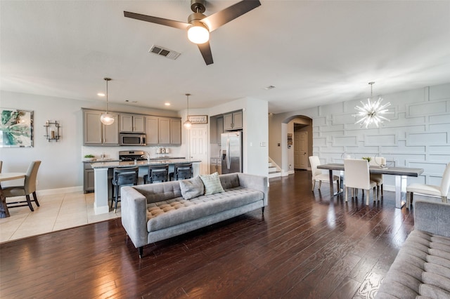 1317 Roadrunner Dr, Little Elm, TX 75068 - living area featuring arched walkways, light wood finished floors, ceiling fan, baseboards, and recessed lighting