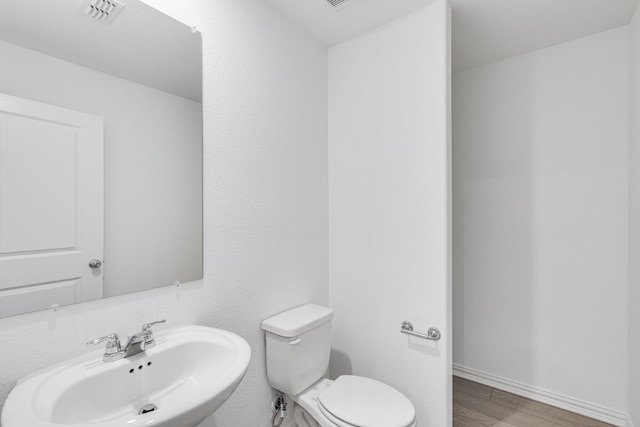 1932 Coleto Rd, Crandall, TX 75114 - half bath featuring a sink, toilet, wood finished floors, and baseboards