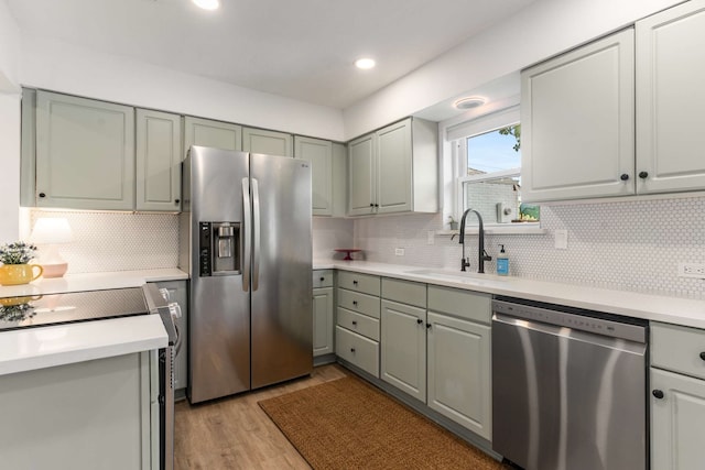 1236 Richland Oaks Dr, Richardson, TX 75081 - kitchen featuring appliances with stainless steel finishes, a sink, light wood-type flooring, light countertops, and tasteful backsplash