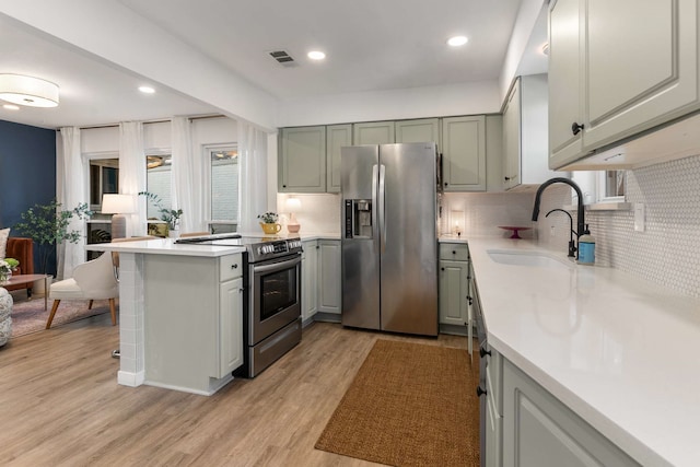 1236 Richland Oaks Dr, Richardson, TX 75081 - kitchen featuring stainless steel appliances, a sink, decorative backsplash, light countertops, and light wood finished floors