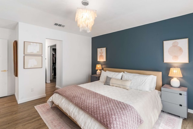 1236 Richland Oaks Dr, Richardson, TX 75081 - bedroom with baseboards, a chandelier, wood finished floors, and a walk in closet