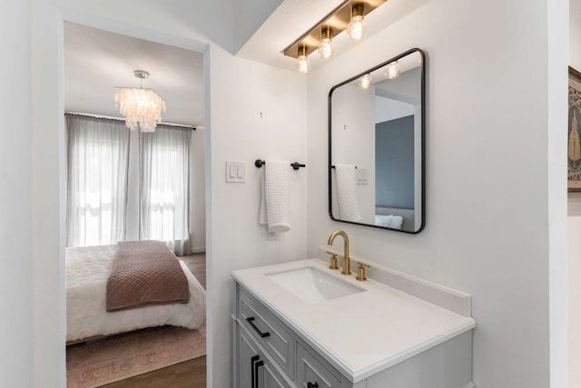 1236 Richland Oaks Dr, Richardson, TX 75081 - bathroom featuring vanity, wood finished floors, a chandelier, ensuite bath, and baseboards