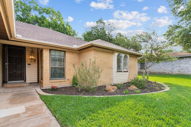 140 Amory Dr, Benbrook, TX 76126 - view of exterior entry featuring a lawn, brick siding, and roof with shingles