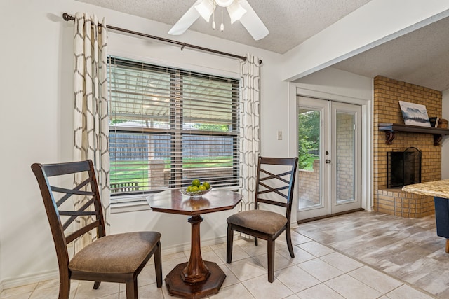 140 Amory Dr, Benbrook, TX 76126 - sitting room featuring a textured ceiling, light tile patterned floors, a brick fireplace, a ceiling fan, and baseboards